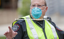 UNL Police Officer Paul Schmeling directs the huge traffic flow for people coming for the free flat 