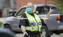 UNL Police Officer Paul Schmeling directs the huge traffic flow for people coming for the free flat 