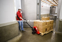 Gary Sullivan, Associate Professor in Animal Science, pulls a pallet load of processed pork toward t