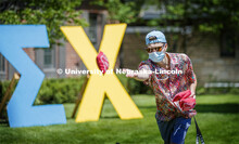 Sigma Chi members play Corn Hole on recruitment day. Sigma Chi members are wearing masks as a result