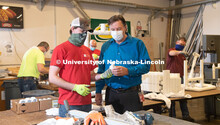 Housing Facilities staff assemble the PVC to make sanitizing stations in the University Facilities S