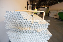 Staff carry the PVC pipe to the workshop area where they assemble the sanitizing stations. Several p