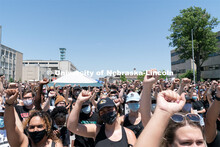 Protestors raise their fists in the air during a moment of silence outside of the Nebraska State Cap