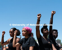 Protestors raise their right arms in the air during a moment of silence outside of Andersen Hall on 