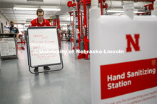 Josh Bruno, strength and conditioning coach, places a sign at the entrance to the weight room. First
