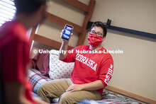 PJ Miguelino talks with Edwin Mendez-Rodriguez in a University Suites Residence Hall room. Photo sho