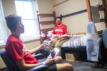 PJ Miguelino talks with Edwin Mendez-Rodriguez in a University Suites Residence Hall room. Photo sho