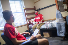 PJ Miguelino talks with Edwin Mendez-Rodriguez in a University Suites Residence Hall room. Photo sho