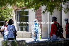 A group of students hang out wearing masks and social distancing. Photo shoot of students wearing ma