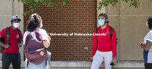 A group of students hang out wearing masks and social distancing. Photo shoot of students wearing ma