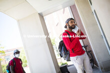 Shemsa Ndahiro puts on a mask. Photo shoot of students wearing masks and practicing social distancin