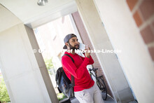 Shemsa Ndahiro puts on a mask. Photo shoot of students wearing masks and practicing social distancin