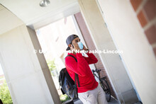 Shemsa Ndahiro puts on a mask. Photo shoot of students wearing masks and practicing social distancin