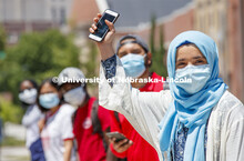 Sonoor Majid waves with her phone. Photo shoot of students wearing masks and practicing social dista