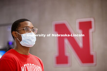 Young man wearing a mask standing next to the Nebraska N. Photo shoot of students wearing masks and 