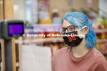 A young woman checking out in the convenience store. Photo shoot of students wearing masks and pract