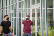 Students socialize outside the Willa Cather Dining Complex. Photo shoot of students wearing masks an