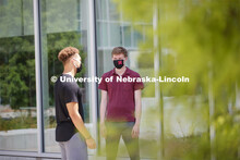 Students socialize outside the Willa Cather Dining Complex. Photo shoot of students wearing masks an