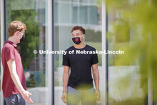 Students socialize outside the Willa Cather Dining Complex. Photo shoot of students wearing masks an