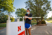 Maggie Ferguson, a May 2020 College of Business graduate, tries out a hand sanitizer station outside