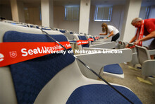Marking classroom seats in Louise Pound Hall as part of preparing the campus for Forward to Fall. A 