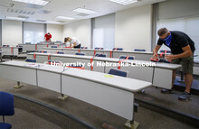 Crews marking classroom seats in Louise Pound Hall as part of preparing the campus for Forward to Fa