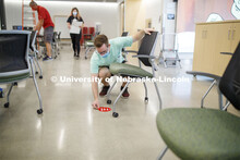 Student worker Alex Cathcart places a seat-available sticker marking in the computer lab of the John