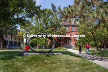 Photo shoot of students on city campus display mask wearing and social distancing. A young man sits 