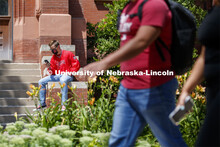 Photo shoot of students on city campus display mask wearing. A masked young man sits outside Richard