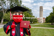 Herbie Husker has a protective mask on while he poses in front of the Mueller Bell tower while weari