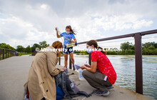 Malayna Wingert, a sophomore from Sterling, NE, lifts a water sample out of Holmes Lake as Anni Poet