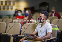 Masked students in an Anderson Hall Lecture Hall are seated for social distancing. Photo shoot of st
