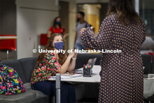 Students visiting between classes in Anderson Hall. Photo shoot of students wearing masks and practi