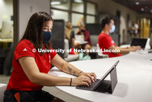 Masked students in Anderson Hall working on computers. Photo shoot of students wearing masks and pra