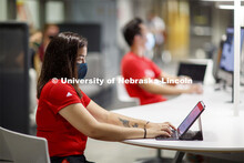 Masked students in Anderson Hall working on computers. Photo shoot of students wearing masks and pra