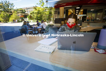 Anna Miles, a freshman from Benson, Arizona, studies from a table with a window view in the Adele Co
