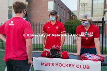 Members of the Nebraska Men’s Hockey Club speak to a student during the HuskerMania Masker Singer 