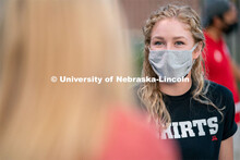 Students converse with one another during the HuskerMania Masker Singer event at Mabel Lee Fields. A