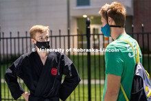 A member of the Nebraska Judo Club speaks to a student during the HuskerMania Masker Singer event at