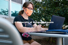 Freshman Journalism major Samantha Grove listens to a lecture through Zoom outside of Andersen Hall 