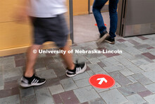Directional floor arrows keep students at a safe distance. Students walk through the hallways inside