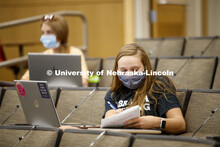 A young woman takes notes in an intro to International Economics in the College of Business. First d