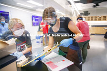 Johanna Ilves, right, and Clarissa Marron work on the report as the two lab partners are separated b
