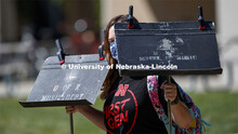 Kirsten Munoz carries the music stands for her outdoor voice lesson with Kevin Hanrahan, associate p