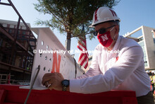 Chancellor Ronnie Green adds signatures to the last beam before it is placed. Due to COVID-19 precau