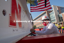 Chancellor Ronnie Green adds signatures to the last beam before it is placed. Due to COVID-19 precau