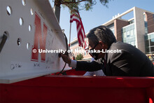College of Engineering Dean Lance Perez adds his signature to the last beam before it is placed. Due