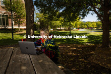 Gabby Huerta zooms her class from a shady bench to the west of Kauffman Academic Residential Center.