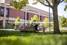 Isabella Kane zooms her class from a shady bench outside of Love Library's Adele Coryell Hall Learni