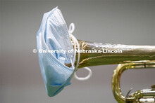 Band members have used ingenuity to cover their horn's bell. Cornhusker Marching Band practice in Co